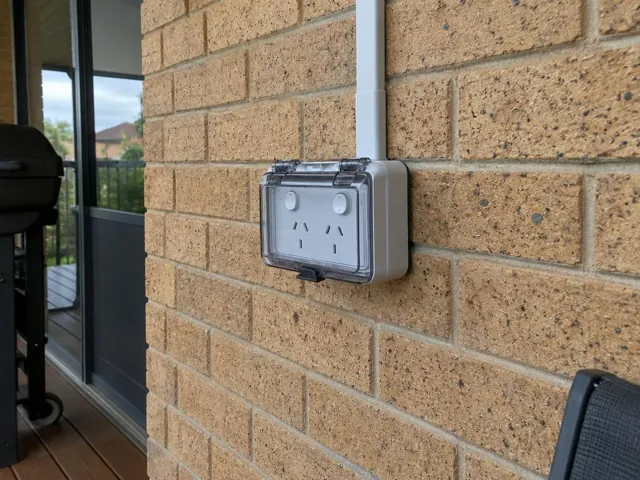 Weatherproof outdoor power point on a brick exterior wall with conduit in Kincumber